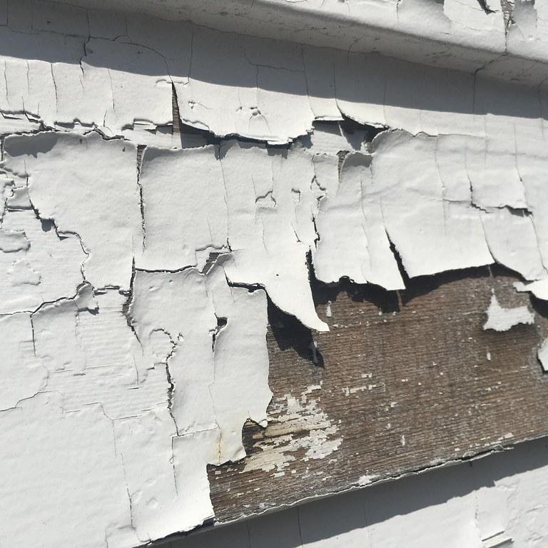 Weathered and peeling paint on a building surface